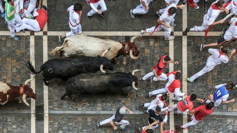 Aerial view of people running with bulls during the San Fermin festival in Spain.