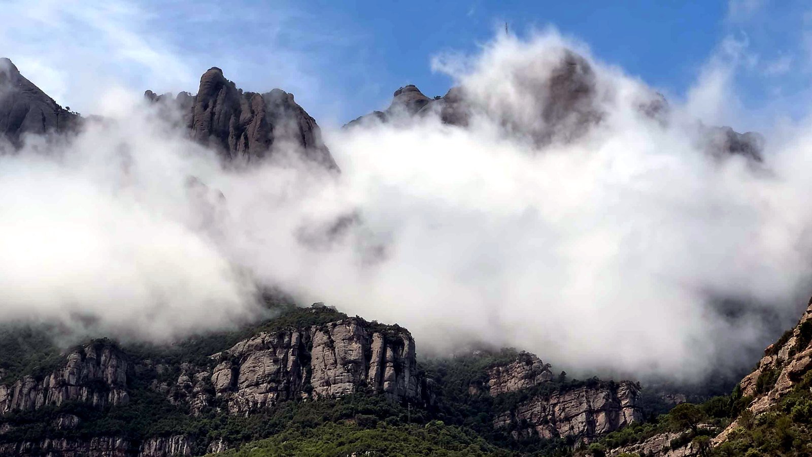 Low clouds drifting around the rocky peaks of Montserrat.