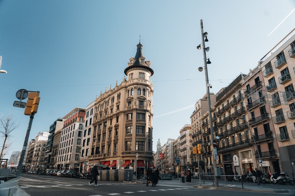 Elegant historic building at a street corner in Barcelona, showcasing urban architecture on a sunny day.
