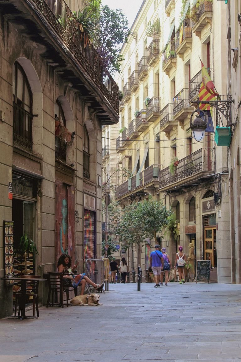 Lively street in Barcelona with people strolling and relaxing in a quaint setting.